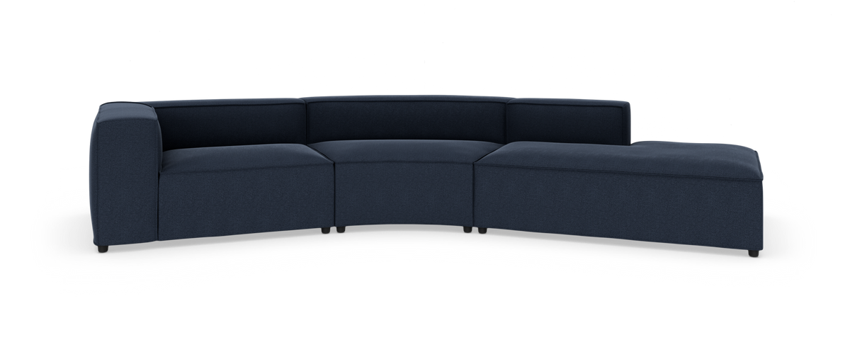 Modulær mørkeblå buet hjørnesofa med chaiselong til højre, frilagt på hvid baggrund.