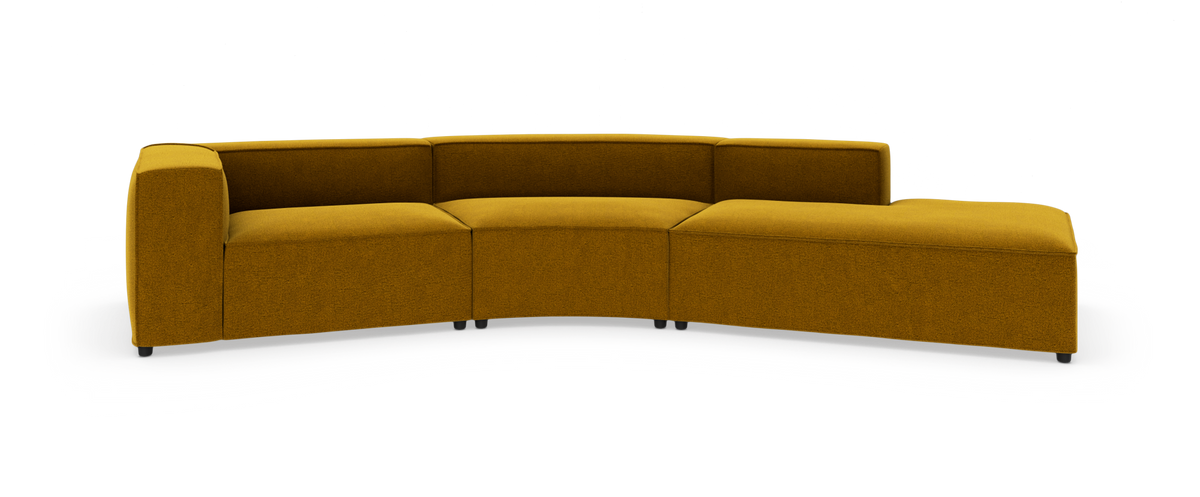 Modulsofa i sennepsgul tekstil, buet sektion med venstre armlæn og chaiselong til højre, fritlagt på hvid baggrund.