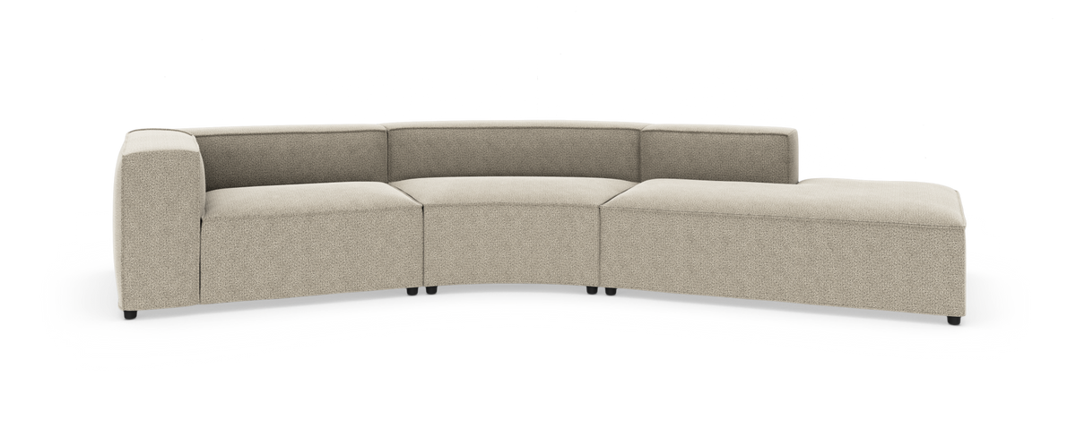 Modulær, buet beige stofsofa med chaiselong, fotograferet på hvid studiebaggrund.