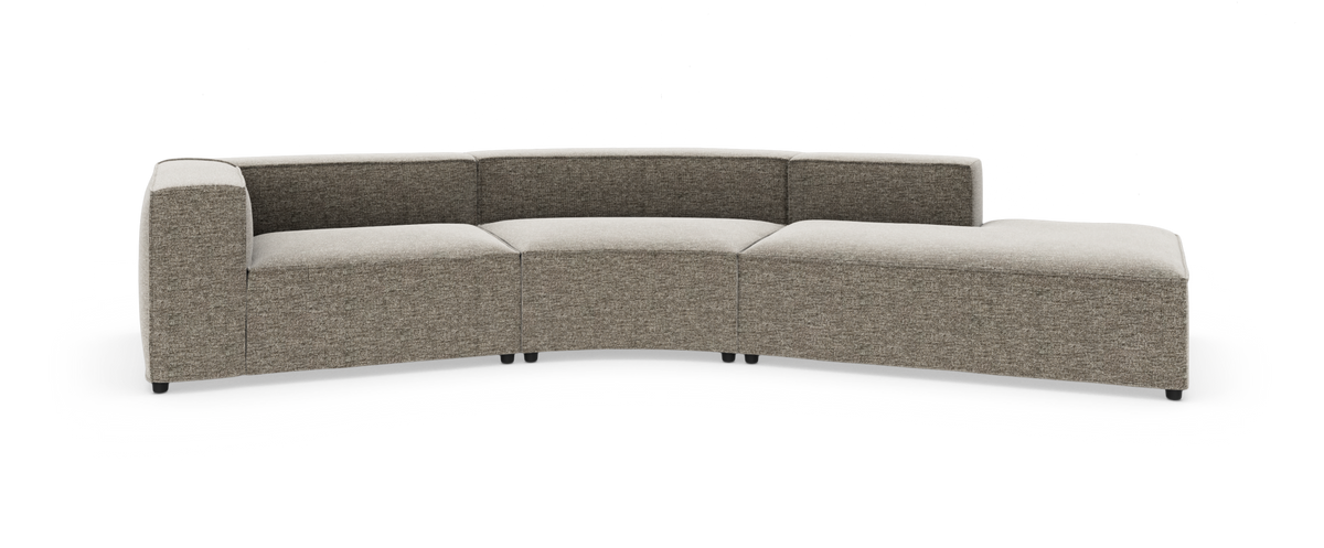 Modulsofa i lys grå‑beige tekstil med buet sektion og chaiselong, fritstående på hvid baggrund.