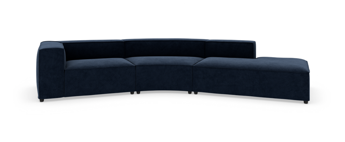 Mørkeblå, buet modulsofa i stof på hvid studiobaggrund.