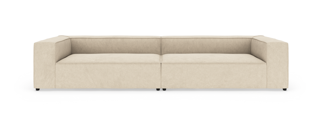 Beige, moderne modulsofa med lav ryg, set forfra mod hvid baggrund.