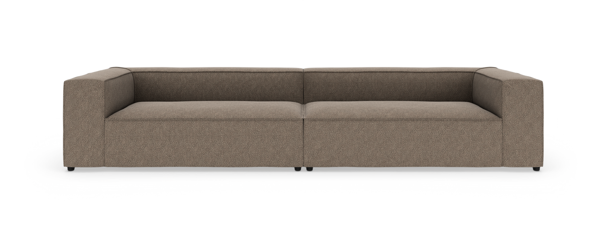 Modulsofa i brun‑beige stof med lave, brede armlæn, fotograferet lige forfra mod hvid studiobaggrund.