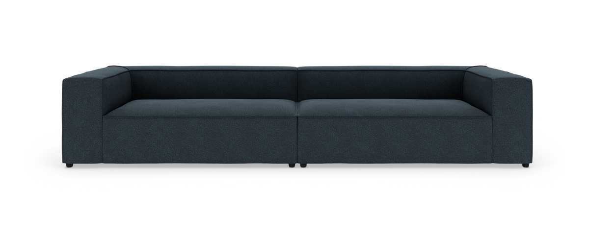 Mørkeblå, lav modulær 2-personers sofa med brede kvadratiske armlæn, set forfra mod hvid baggrund.