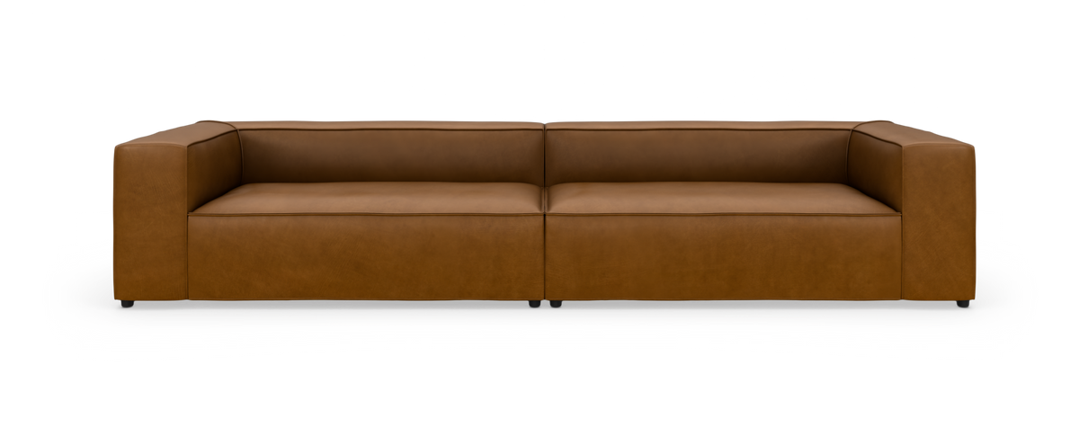Lav, moderne 3-personers sofa i cognacfarvet læder, fotograferet forfra mod hvid baggrund.