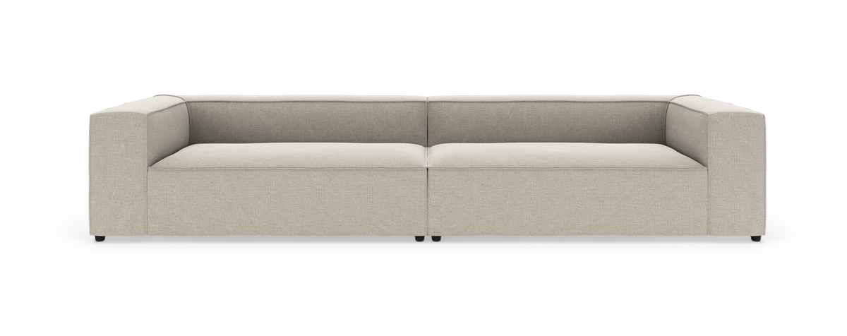 Beige, moderne modulsofa med lave rygge og brede armlæn, set lige forfra.