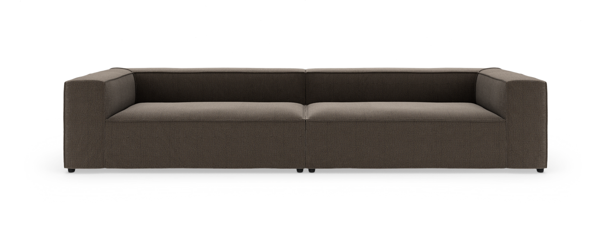 Brun lav modulsofa med stramme linjer set forfra på hvid studiebaggrund.
