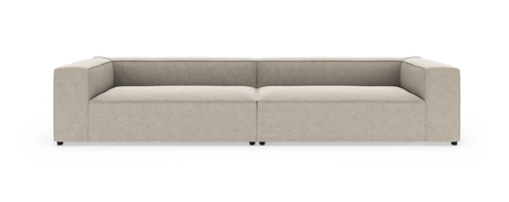 Beige, lav modulsofa med brede armlæn, vist lige forfra på hvid baggrund.