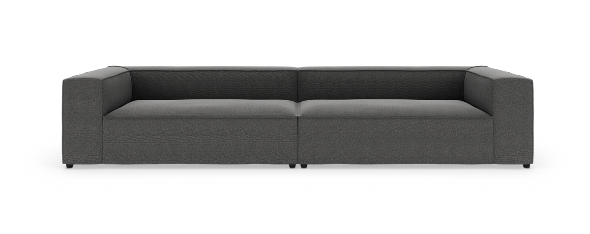Mørkegrå modulsofa med lav ryg og brede armlæn, to-sæders, på hvid studiobaggrund.