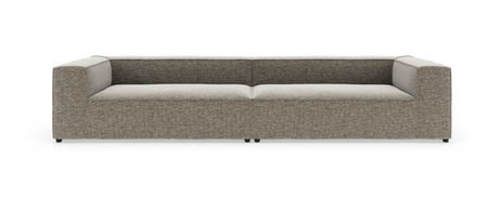Moderne lav modulsofa i grå/beige stof med brede armlæn, set forfra på hvid baggrund.