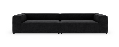 Sort modulsofa med bred, lav siddehøjde og rette armlæn, fotograferet forfra mod hvid baggrund.