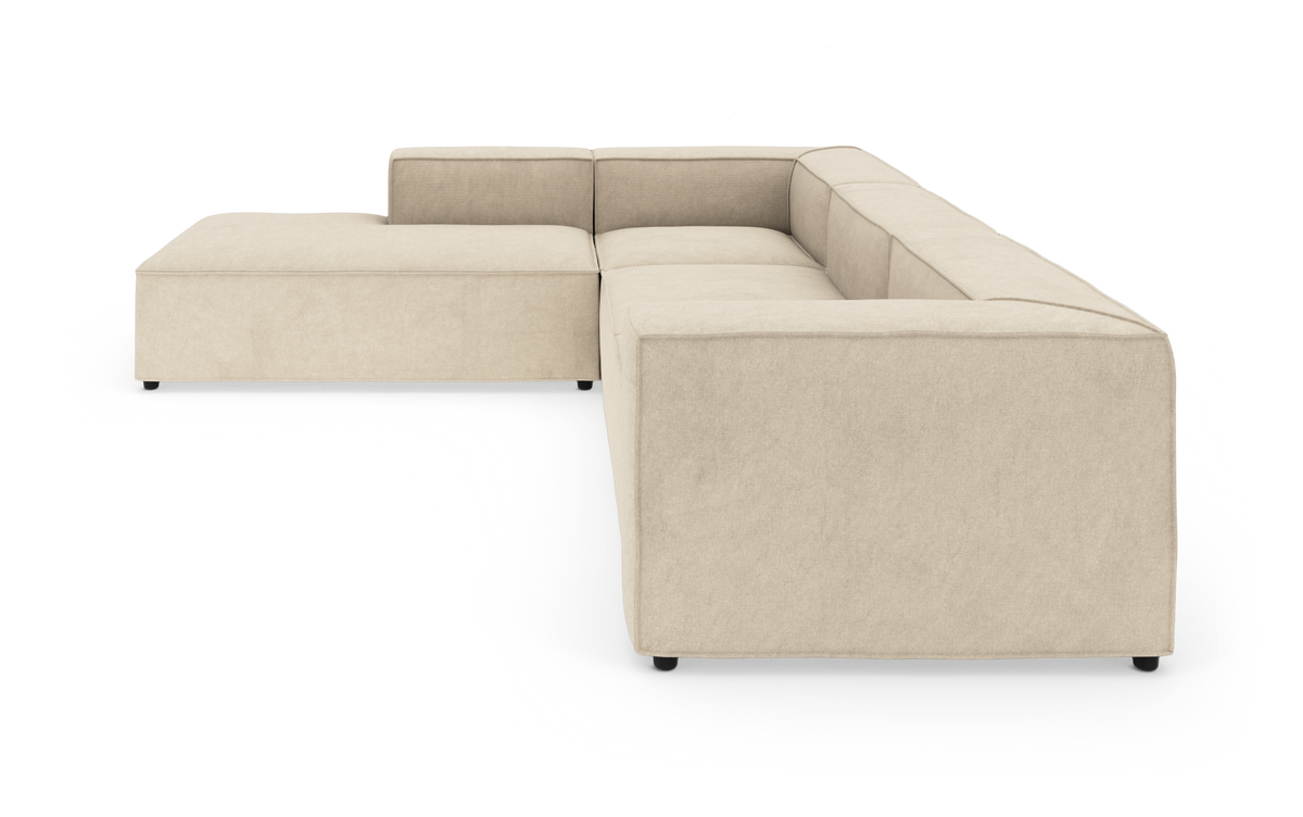 Beige modulsofa i U‑form med bred venstre chaiselong, studiefoto på hvid baggrund.