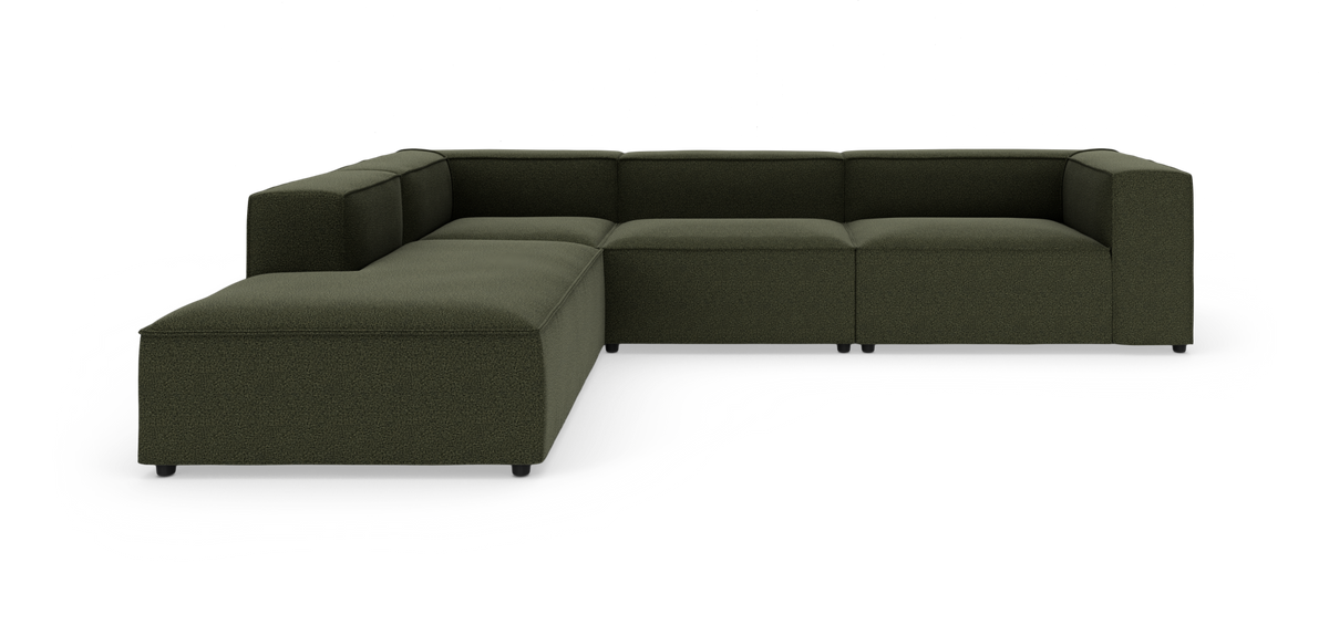 Mørkegrøn modulsofa i U‑form på hvid studiebaggrund.