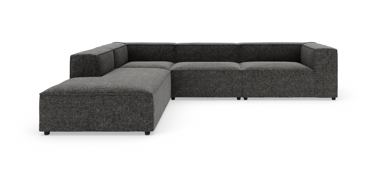 Mørkegrå modulopbygget U‑sofa med lav ryg og brede armlæn fotograferet i studie på hvid baggrund.