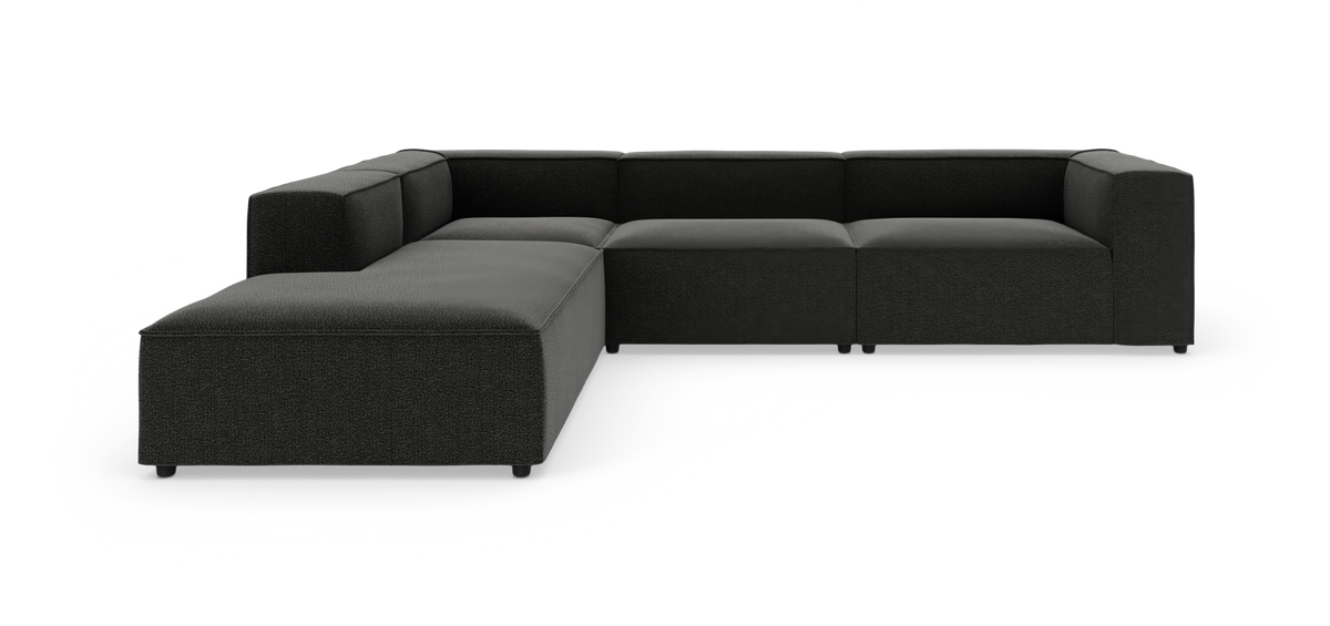 Sort L-formet modulsofa med bred chaiselong, fotograferet i studie fra en let frontal vinkel.