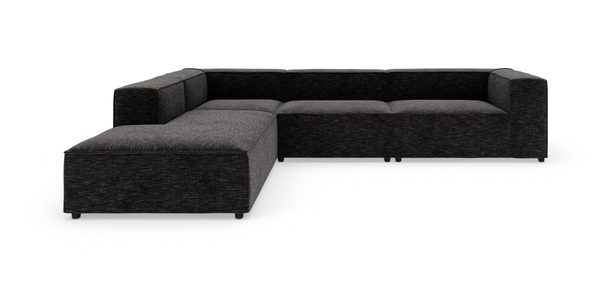 L-formet modulsofa i mørkegråt stof på hvid studiobaggrund.