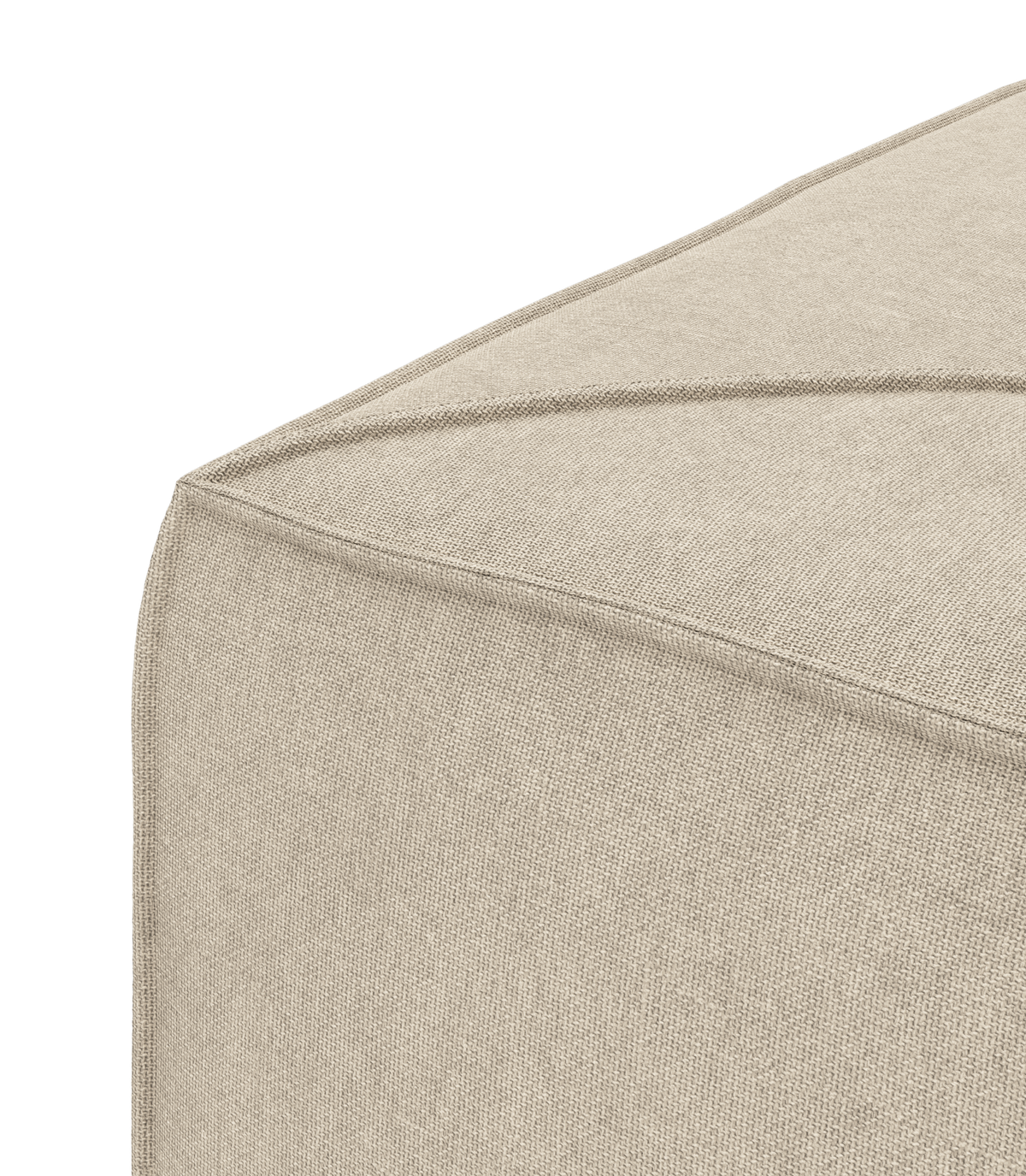 Nærbillede af hjørne på beige stofpuf med synlige sømme mod hvid baggrund.