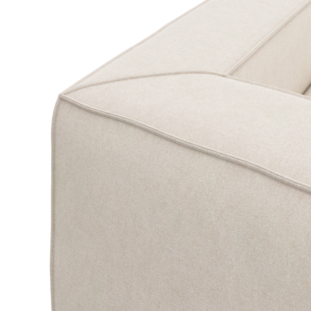Nærbillede af hjørnet på en beige stofsofa med markeret pipingdetalje mod hvid baggrund.