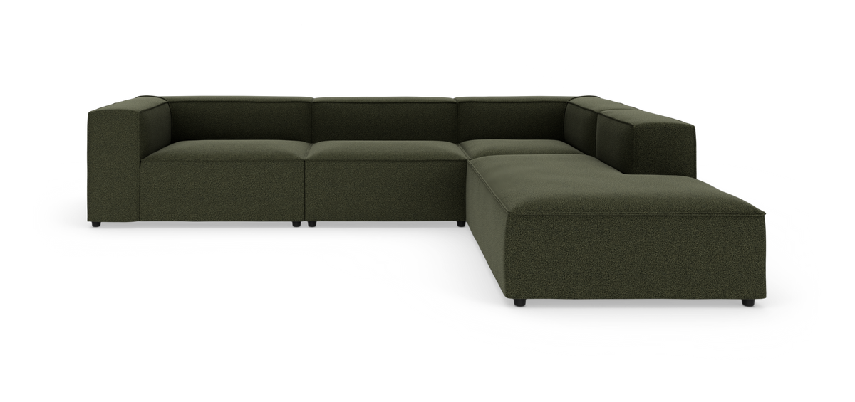 Modulær L‑formet sofa i mørkegrønt stof, lav og dyb med brede armlæn.