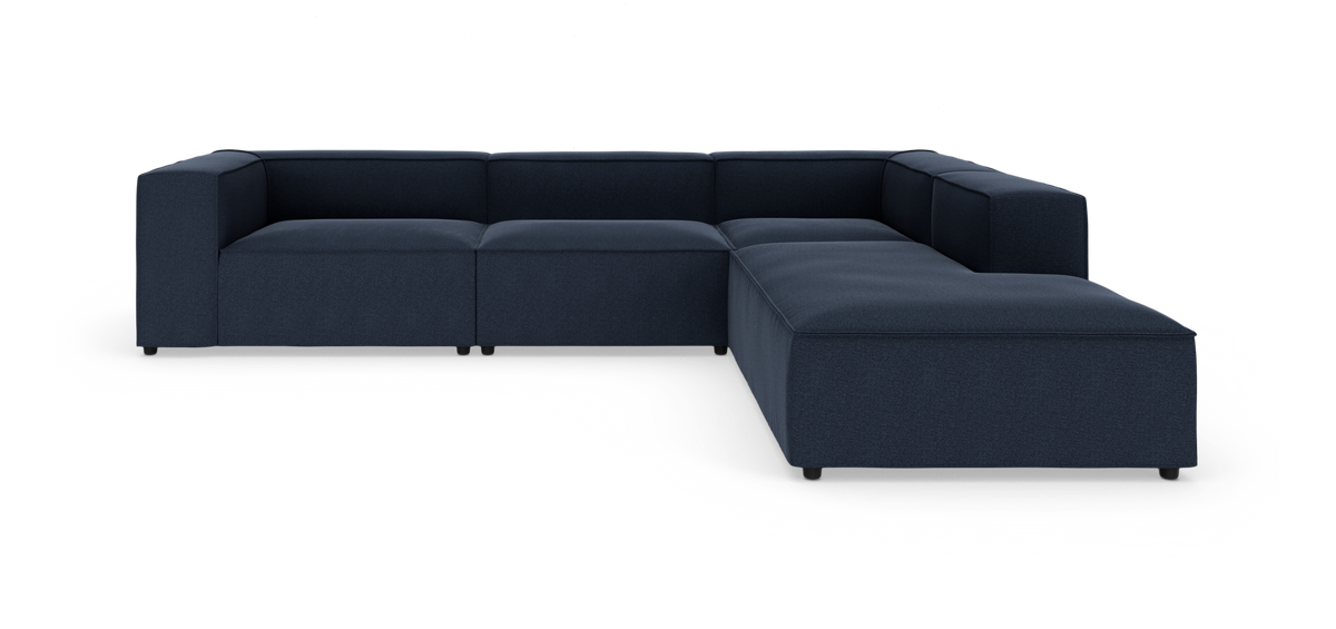Modulær L-formet mørkeblå hjørnesofa med brede armlæn og lav sæde, vist mod hvid baggrund.
