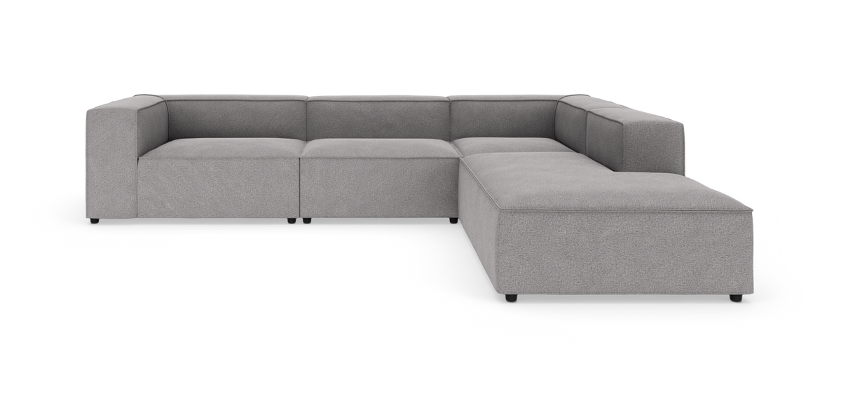 L-formet modulsofa i lysegråt stof, fotograferet mod hvid studiebaggrund.