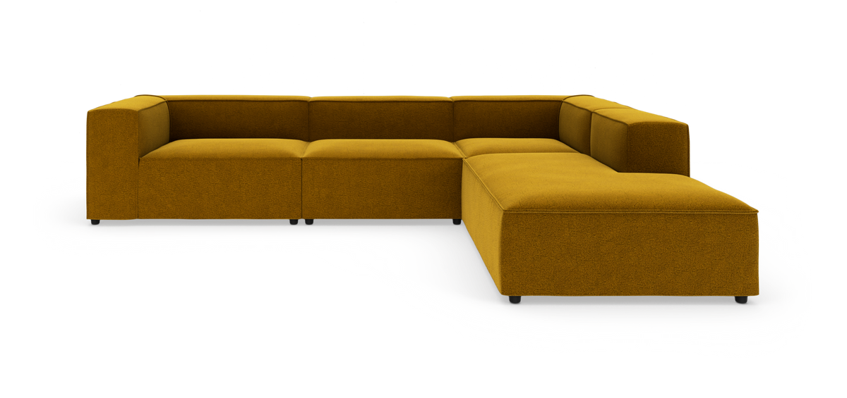 Modulær hjørnesofa i okkergult stof på hvid baggrund.