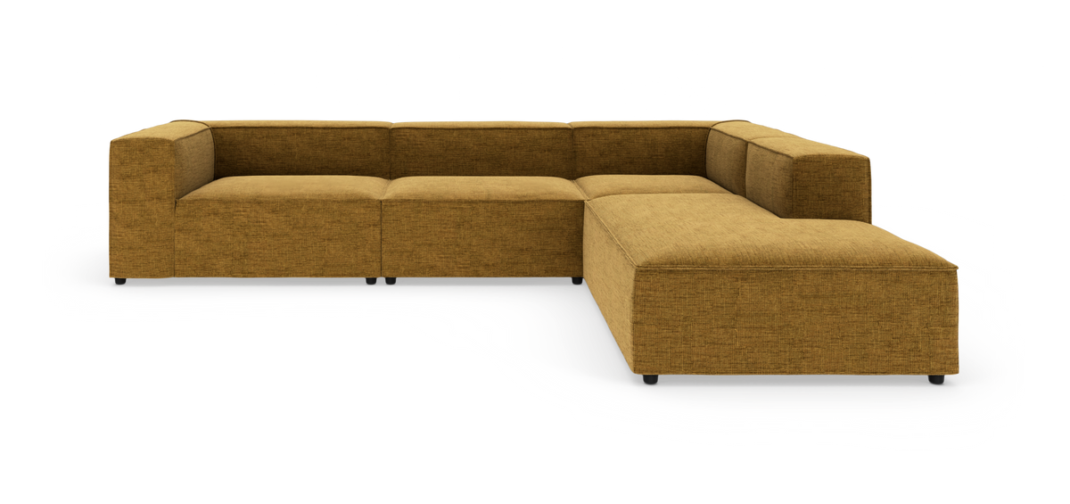 Modulær L‑formet hjørnesofa i sennepsgul tekstil, moderne og lav med brede armlæn, frilagt på hvid baggrund.