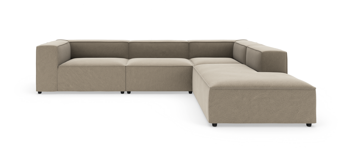 Modulær L‑formet hjørnesofa i beige stof med brede blokarmlæn og lavt sæde, moderne minimalistisk design.