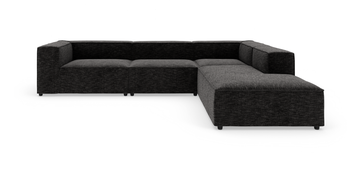 L‑formet mørkegrå modulsofa i stof på hvid studiobaggrund.