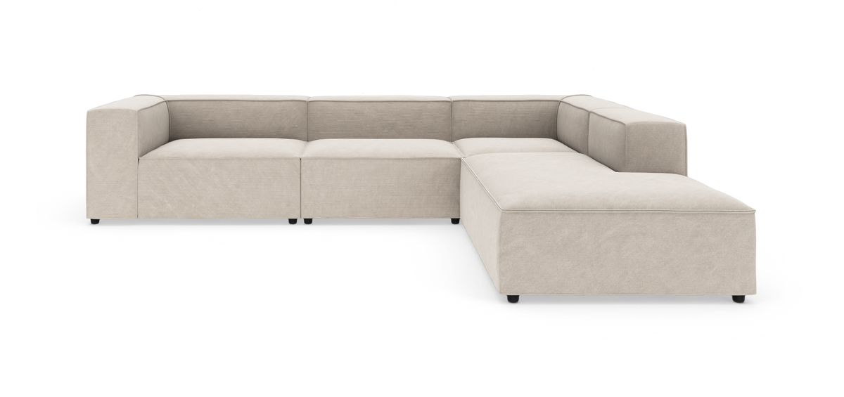 Beige modulbaseret hjørnesofa med brede armlæn i L‑form, fritlagt på hvid baggrund.