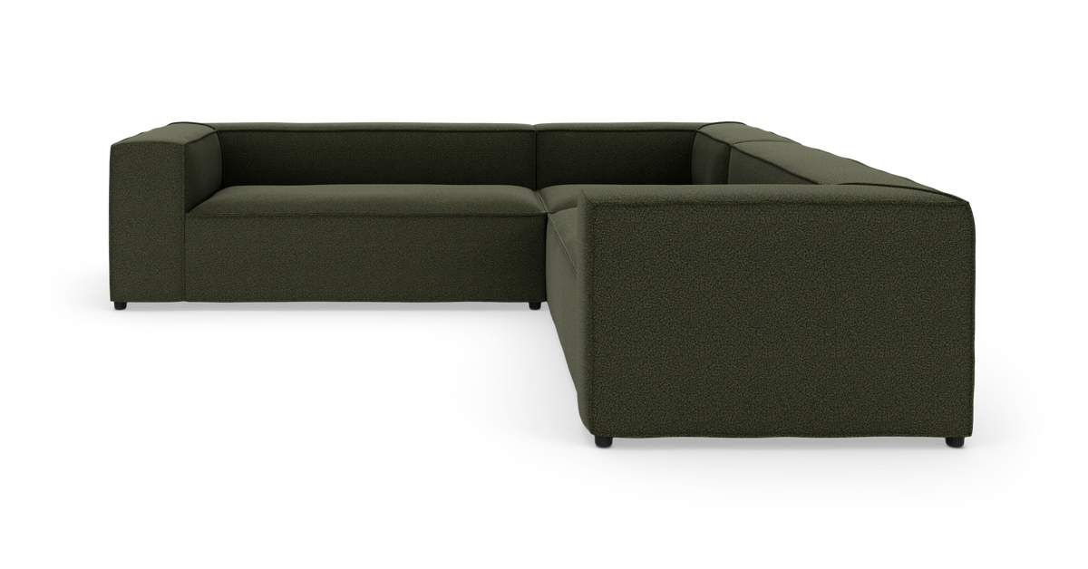 Mørkegrøn L-formet modulsofa i tekstil på hvid studiobaggrund.
