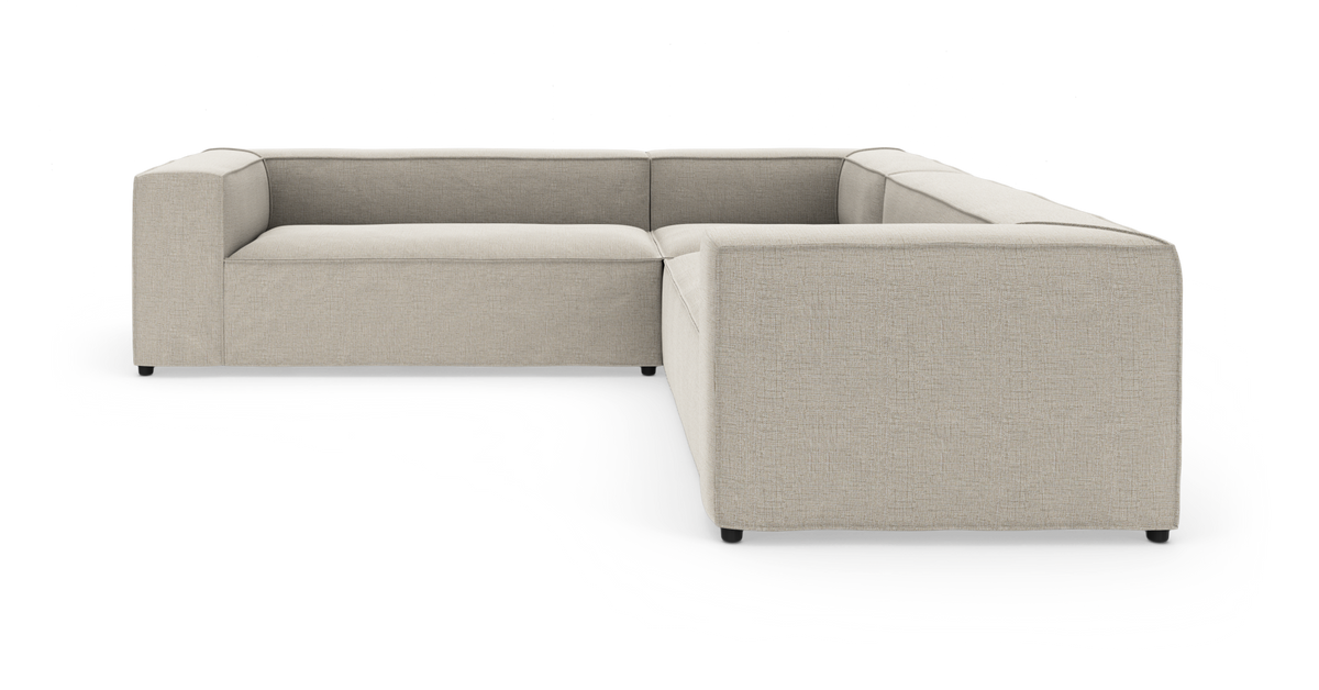 Beige L‑formet modulsofa i studieopsætning på hvid baggrund.