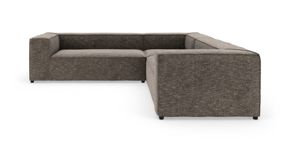 L-formet modulsofa i mørkegråt tekstil, lav og bokset design med brede armlæn.