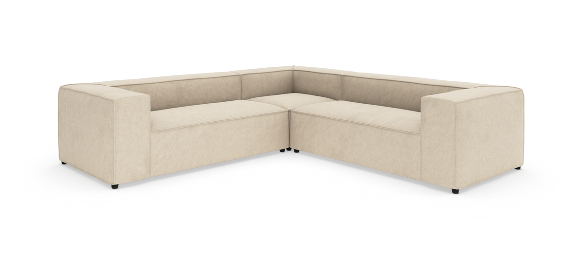 Beige L‑formet modulsofa med brede armlæn, frilagt på hvid baggrund.