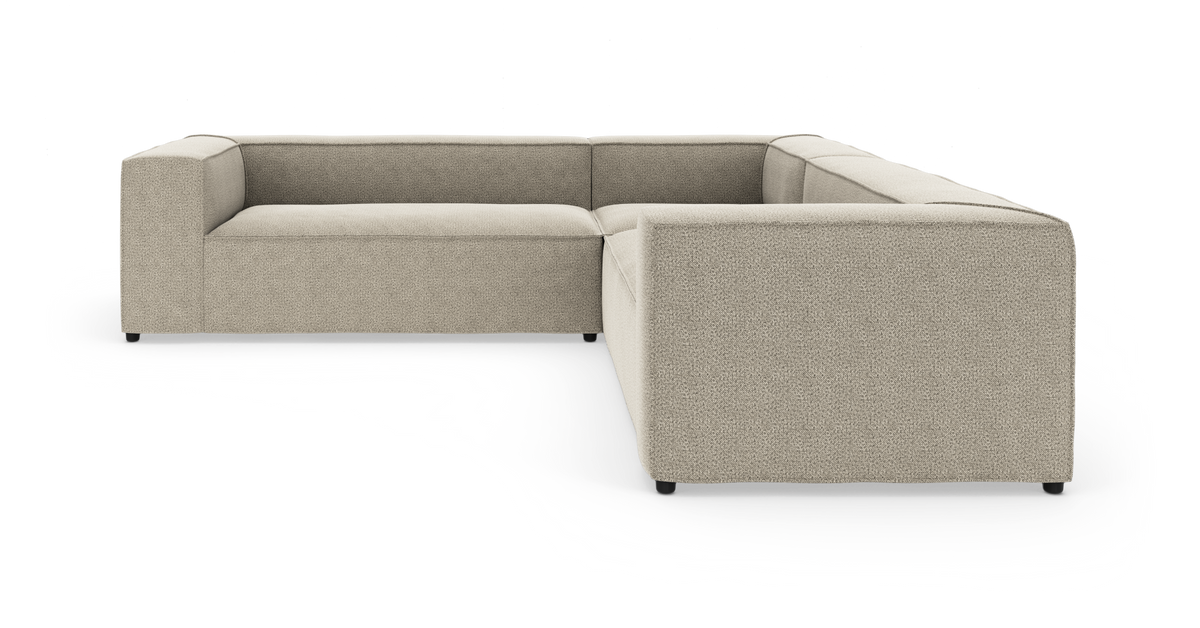 Beige L-formet modulsofa med brede armlæn, frilagt på hvid baggrund.
