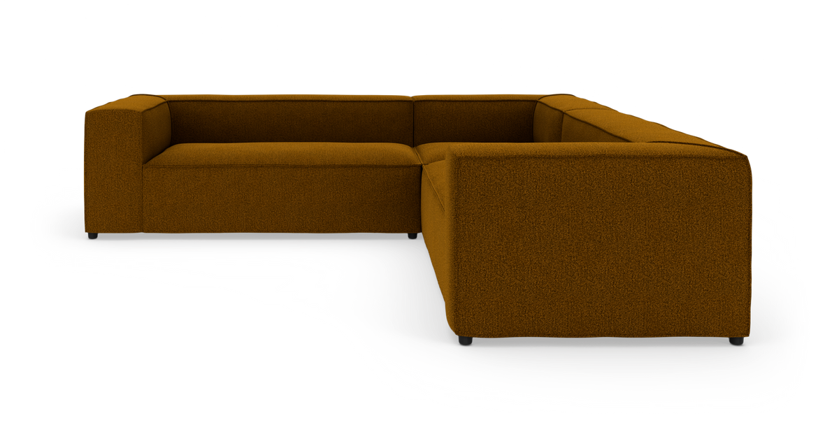 Modulær L‑formet hjørnesofa i okkergul/brun tekstil, fritstående mod hvid baggrund.