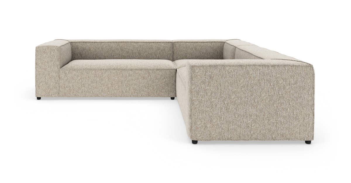 L‑formet modulsofa i beige stof med brede, lige armlæn, set skråt forfra på hvid baggrund.
