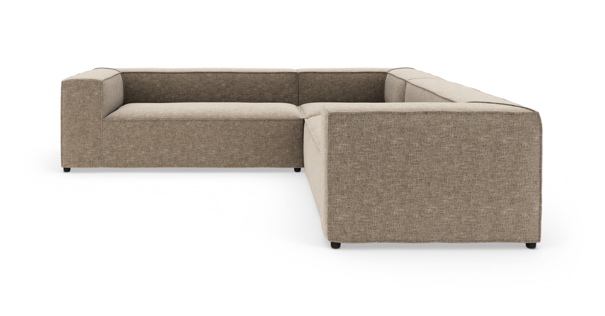 L-formet modulsofa i beige stof, frilagt på hvid baggrund.