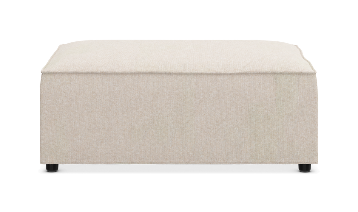 Beige kvadratisk puf/ottoman i stof med små sorte fødder, frontvisning.