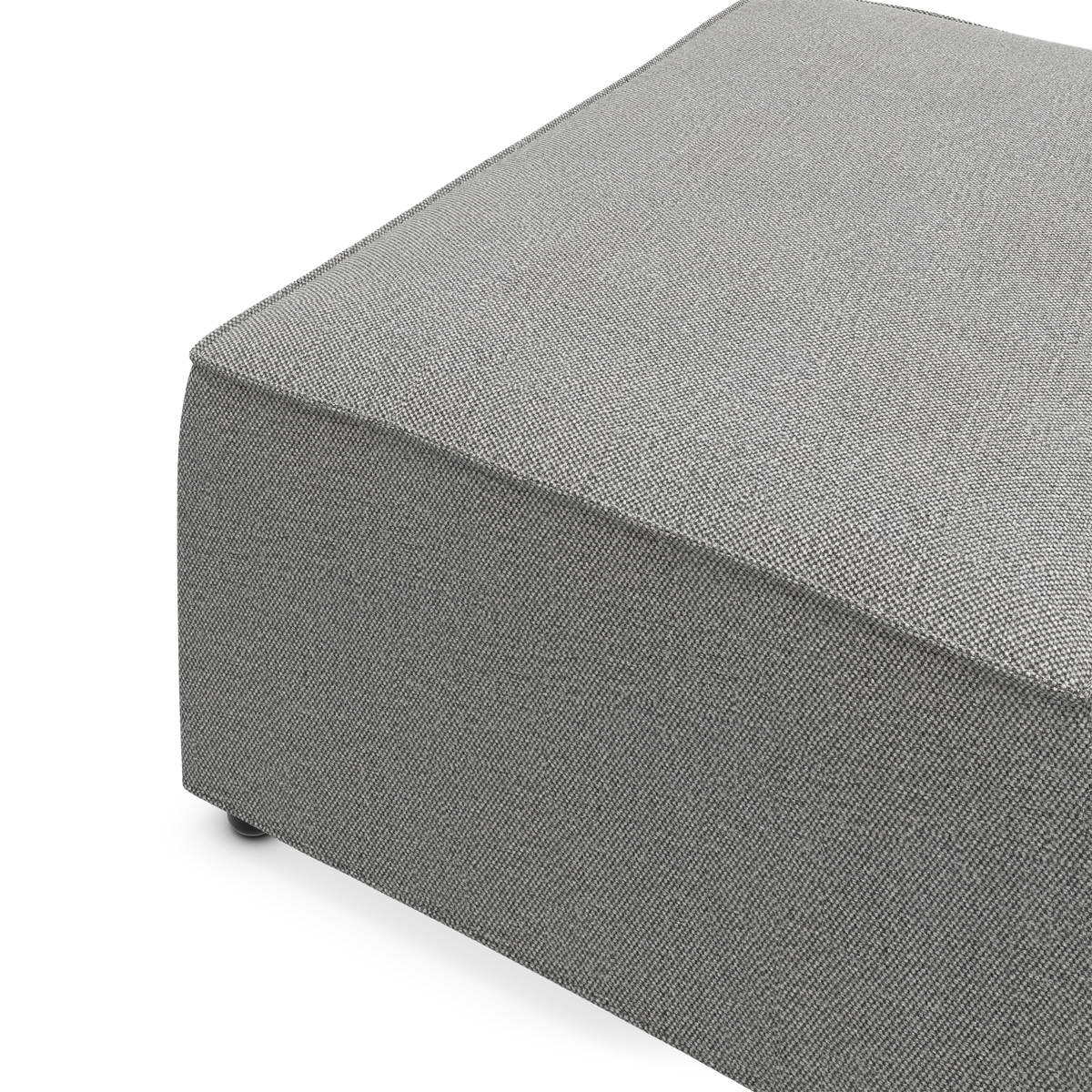 Grå, tekstureret firkantet pouf/ottoman i stof, nærbillede i skrå vinkel på hvid baggrund.