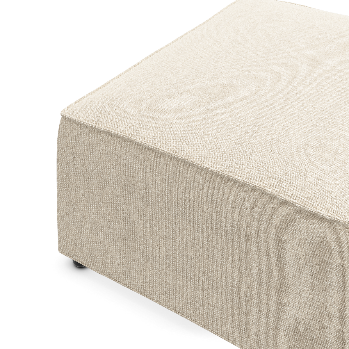 Beige tekstilbetrukket ottoman/puf på hvid baggrund, studiebillede.
