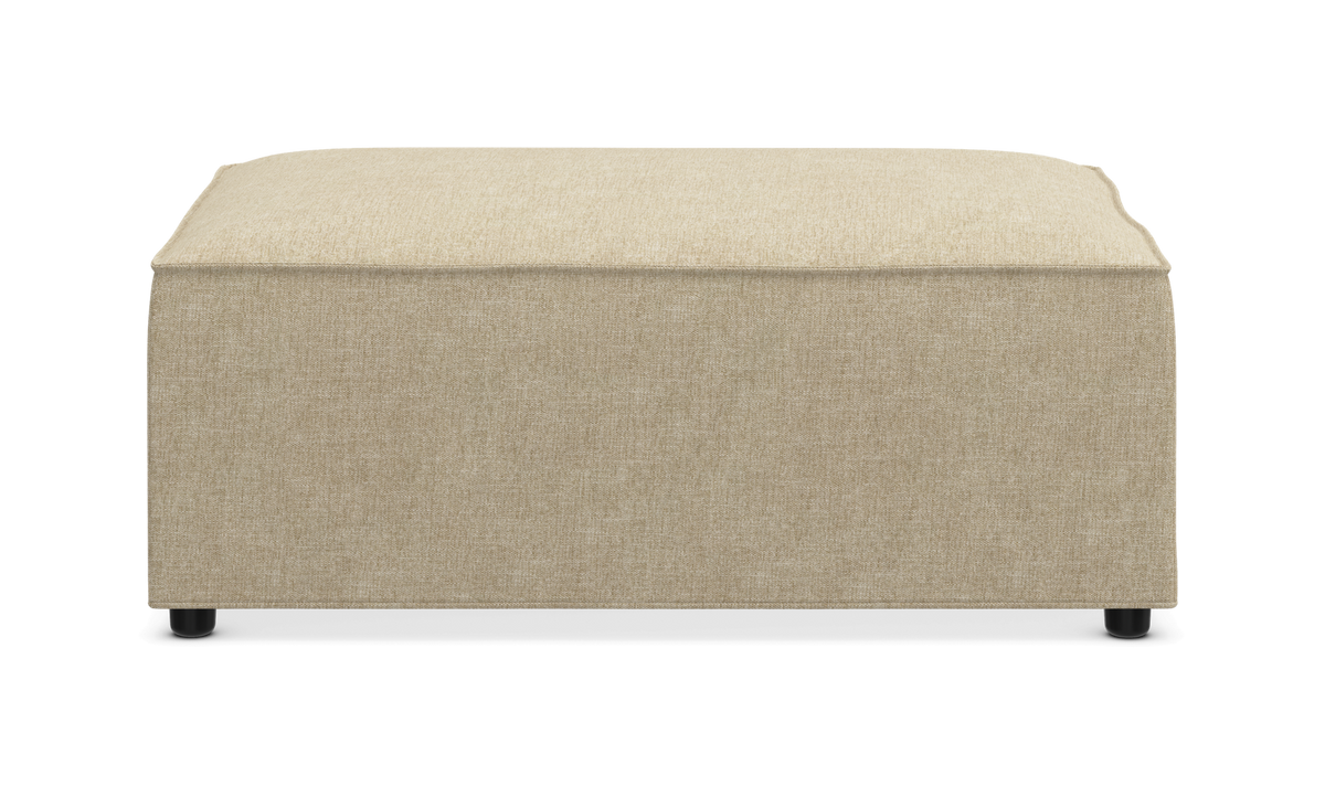 Beige kvadratisk puf i stof, frontvisning mod hvid baggrund.