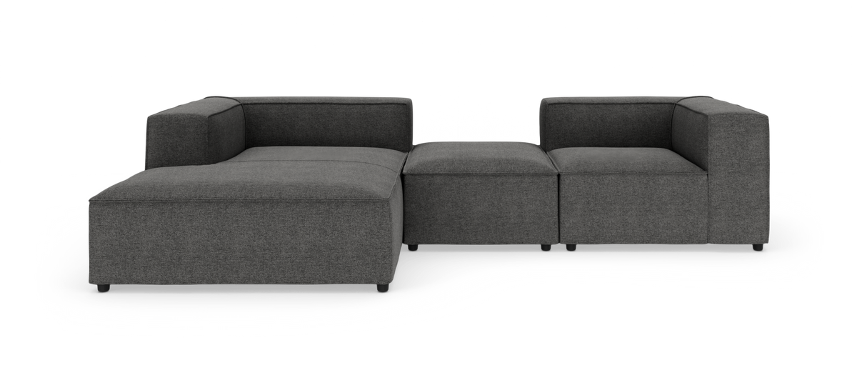 Mørkegrå modulsofa i L‑form, fritlagt på hvid baggrund.
