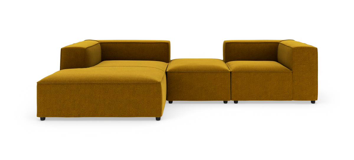 Modulsofa i sennepsgul polstring med venstre chaiselong, to midtermoduler og højre hjørnemodul, frilagt på hvid baggrund.