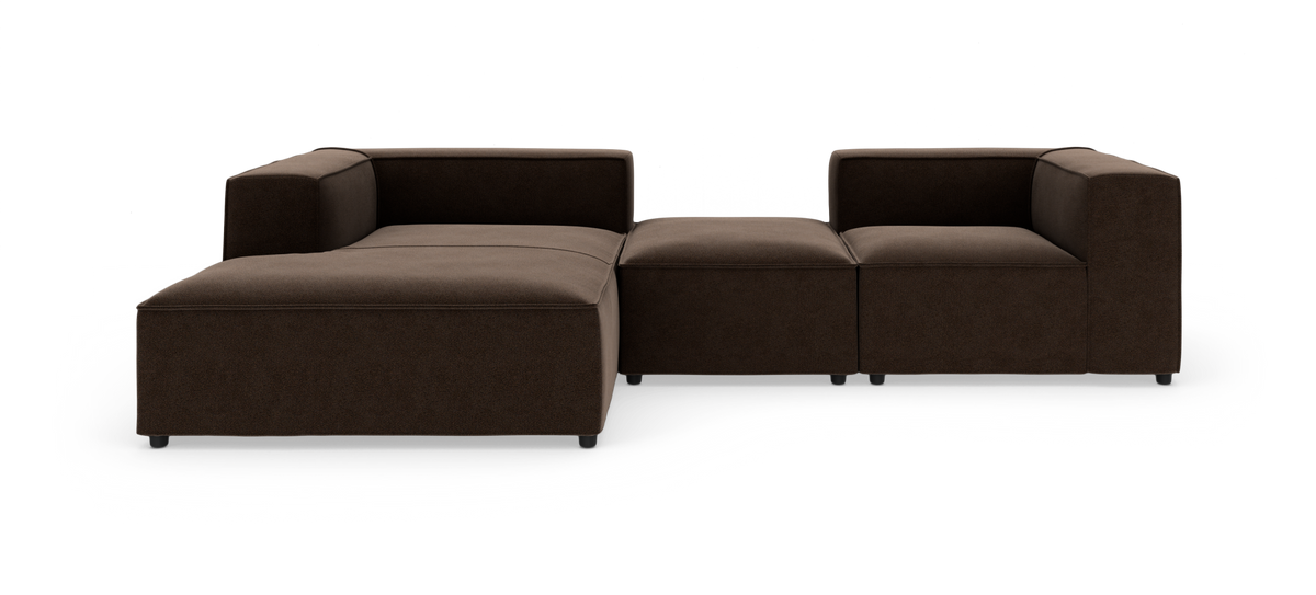Modulsofa i mørkebrunt stof med lave ben, fotograferet lige forfra i studie på hvid baggrund.