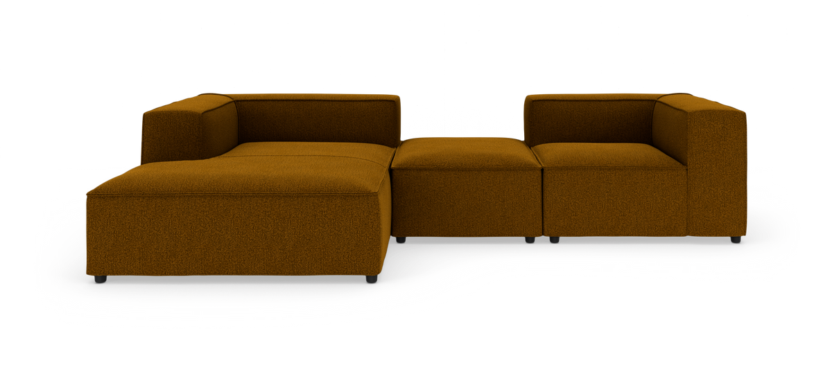 Modulær sennepsgul stofsofa med chaiselong til venstre på hvid studiobaggrund.