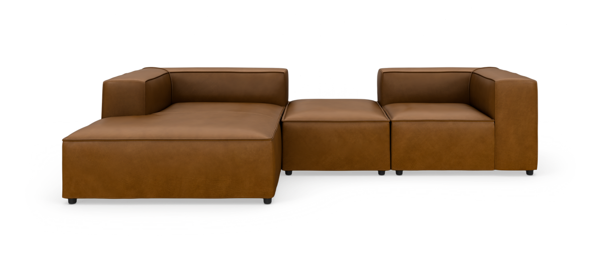 Modulsofa i brunt læder med chaiselong til venstre, vist i studie mod hvid baggrund.