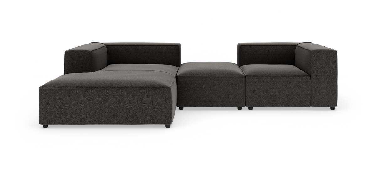 Modulsofa i mørkegråt stof med venstre chaiselong, frilagt på hvid baggrund.