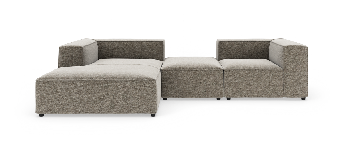Modulsofa i grå‑beige stof med venstrevendt chaiselong, vist på hvid studiobaggrund.