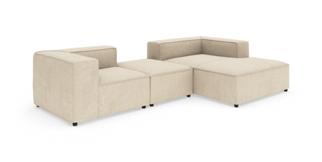 Beige modulsofa i stof – lav L‑formet hjørnesofa med bred chaiselong, frilagt på hvid baggrund.